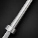 Angled close-up of silver Olympic barbell sleeve showing polished metal texture and collar detail